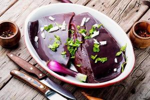 Raw uncooked liver for cooking on wooden table photo