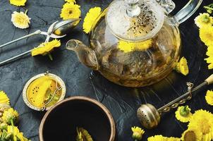 tetera de vidrio con té de flores, medicina herbaria foto
