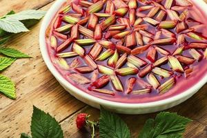 Pie with rhubarb and raspberries on old wooden background photo