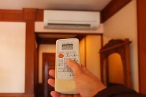 hand holding air conditioner remote controller photo