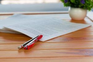 red pen on blurred paperwork in office photo