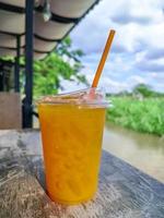 glass of fresh orange juice on wooden table photo