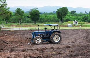 old blue tractor in middle of farm photo