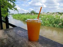 glass of fresh orange juice on wooden table photo