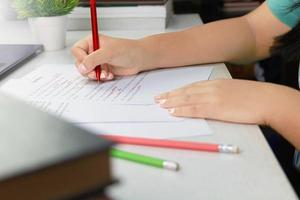 hand holding red pen over proofreading paper photo