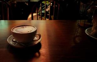 taza de café caliente en la mesa de madera foto