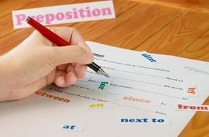 English preposition work sheet on wooden table photo
