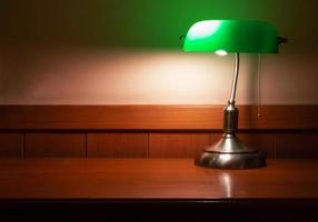 lámpara vintage con pantalla verde en un escritorio de madera foto