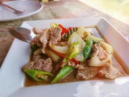 Thai stir fried pork with hot pepper in white plate photo