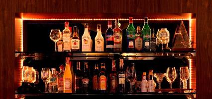 bottles of liqour on shelf in bar at night photo