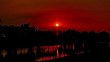 puesta de sol y silueta sobre el campo foto