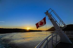 bandera canadiense en un ferry al atardecer foto