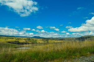 Beautiful green hill view of Australia countryside with cloudy sky. photo