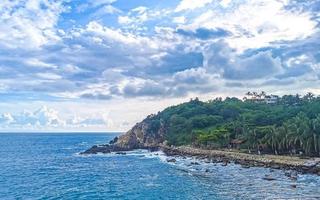 Beautiful surfer waves rocks cliffs at beach Puerto Escondido Mexico. photo