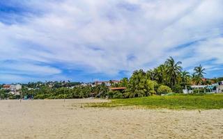 Palms parasols sun loungers beach resort Zicatela Puerto Escondido Mexico. photo