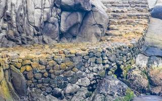 Beautiful surfer waves rocks cliffs at beach Puerto Escondido Mexico. photo