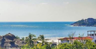 Palms parasols sun loungers beach resort Zicatela Puerto Escondido Mexico. photo