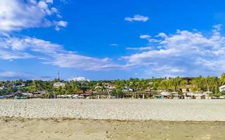 Palms parasols sun loungers beach resort Zicatela Puerto Escondido Mexico. photo