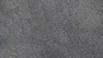 Textured gray concrete background. Old wall or floor made of dark gray cement. Scuffed and cracked. Copy space. Attrition. photo