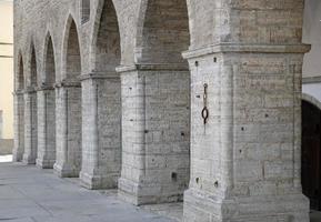 Classic architectural column and arch. Details of architecture of medieval building. Element of exterior building with columns and arches of old town hall in central square of Old Tallinn, Estonia. photo