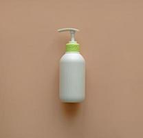 White corrugated bottle surface soap dispenser pump. Skin care Lotion. Bathing essential product. Shampoo bottle. Mock-up pump bottle of moisturizing lotion, soap, or sanitizer on beige background. photo