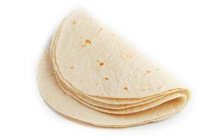 Tortilla on a white isolated background. Corn tortilla or simply tortilla is a type of thin unleavened bread made from Hominy. photo