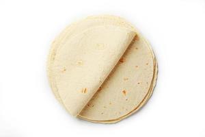 Tortilla on a white isolated background. Corn tortilla or simply tortilla is a type of thin unleavened bread made from Hominy. photo