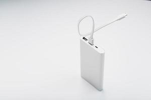 Power Bank for charging your smartphone on a white background. Universal external battery for gadgets free space and minimalistic composition. photo