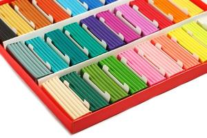 Multicolored plasticine in a box on a white background, material for modeling. photo