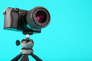 Professional camera on a tripod, on a blue background. Record videos and photos for your blog or report.