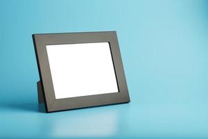 Black photo frame with empty space on a blue background.