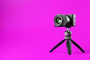 Professional camera on a tripod, on a pink background. Record videos and photos for your blog or report.