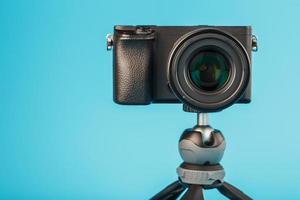 Professional camera on a tripod, on a blue background. Record videos and photos for your blog or report.