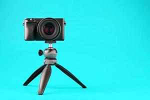 Professional camera on a tripod, on a blue background. Record videos and photos for your blog or report.