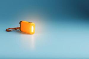 Orange led Flashlight with a carabiner on a blue background. LED lights in flight. photo