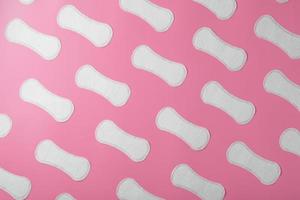 Sanitary pad on a pink background in the form of a diagonal pattern. Textured background over the entire screen. photo