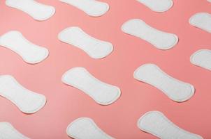 Sanitary pad on a pink background in the form of a diagonal pattern. Textured background over the entire screen. photo