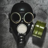 Gas mask on a black stone background, protection from dangerous infection. photo
