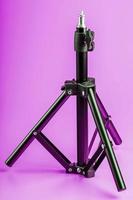 Tripod on pink background for photo-video camera and flash. Free space photo