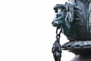 Sculpture of a lion's head in profile made of metal, on a white background. photo