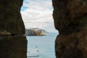 View of the sea coast through the window in the fortress. photo