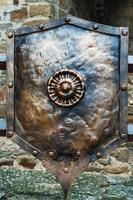 Medieval antique metal shield, with a textured surface. photo