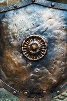 Medieval antique metal shield, with a textured surface. photo