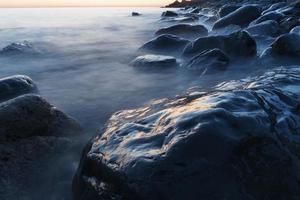 agua de mar lavando las rocas de la costa. foto