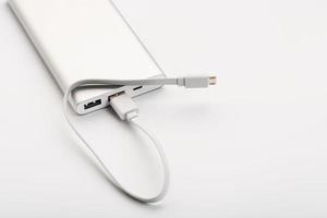 Powerbank for charging mobile devices with cable, on a white background. photo