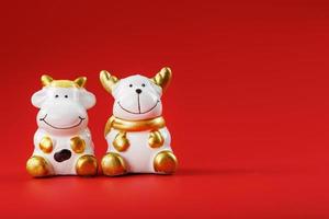 A pair of cow and bull Figures on a red background, with free space. photo