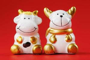 A pair of cow and bull Figures on a red background, with free space. photo