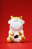 Cow figurine on a red background, new year's concept. Free space. photo