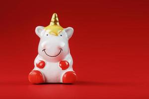 Small figure of a unicorn on a red background. The concept of magic, children's dreams photo