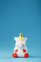 Unicorn figurine on a blue background with free space. photo